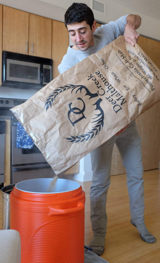 Kenny Gould pours the grain into his mash tun.